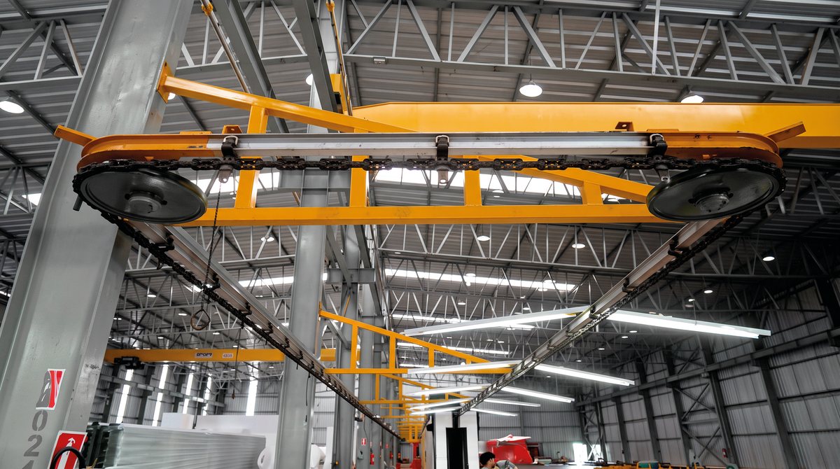 Curva do transportador aéreo TPI com corrente e trolleys forjados no teto do galpão